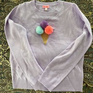 Purple sweater with ice cream cone logo on front.